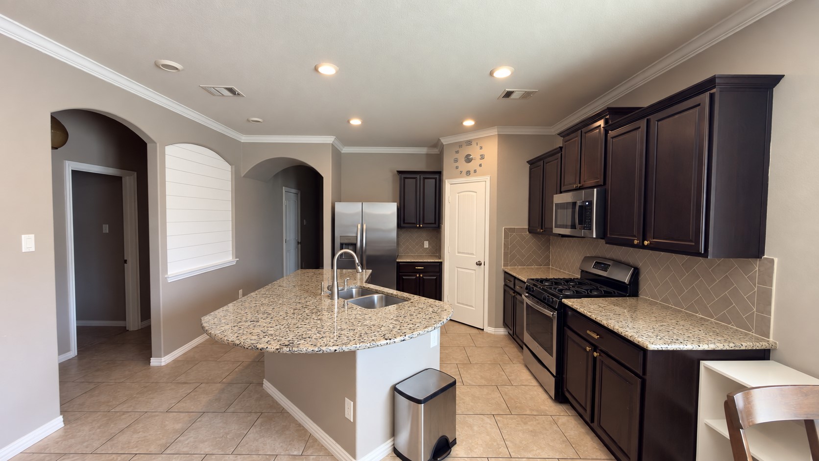 2500 Rough Berry Road Pflugerville, TX 78660 - Photo 13 of 15 Rich dark cabinetry pairs beautifully with stone countertops and tile flooring in this functional kitchen.