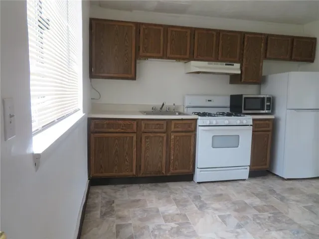 a kitchen with a stove sink and cabinets