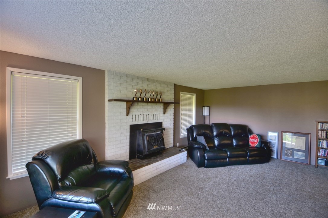 18233 Melon Court Southwest Rochester, WA 98579 - Photo 3 of 25 a living room with furniture a fireplace and a flat screen tv
