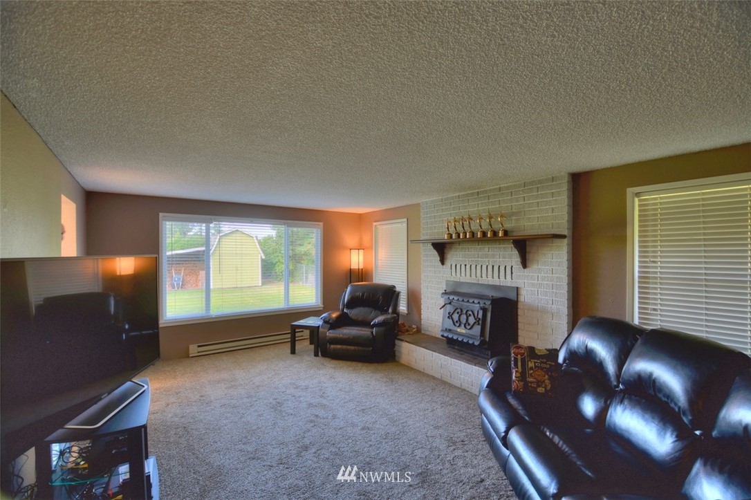 18233 Melon Court Southwest Rochester, WA 98579 - Photo 4 of 25 a living room with furniture and a fireplace