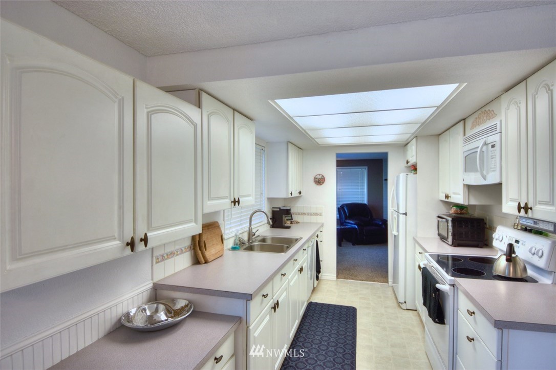 18233 Melon Court Southwest Rochester, WA 98579 - Photo 8 of 25 a kitchen with granite countertop a sink stove and cabinets