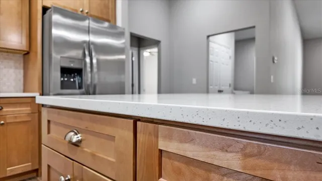 a kitchen with a stove a sink dishwasher a refrigerator and cabinets with wooden floor