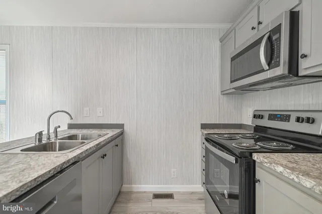 a kitchen with stainless steel appliances granite countertop a sink stove and microwave