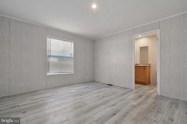 an empty room with wooden floor and a window