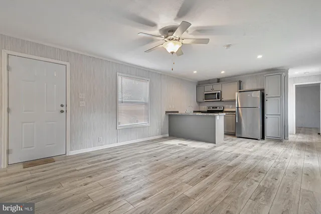 a view of a kitchen with a fridge wooden floor and a kitchen