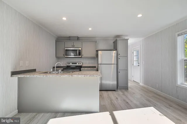 a kitchen with a refrigerator a stove top oven and a counter space