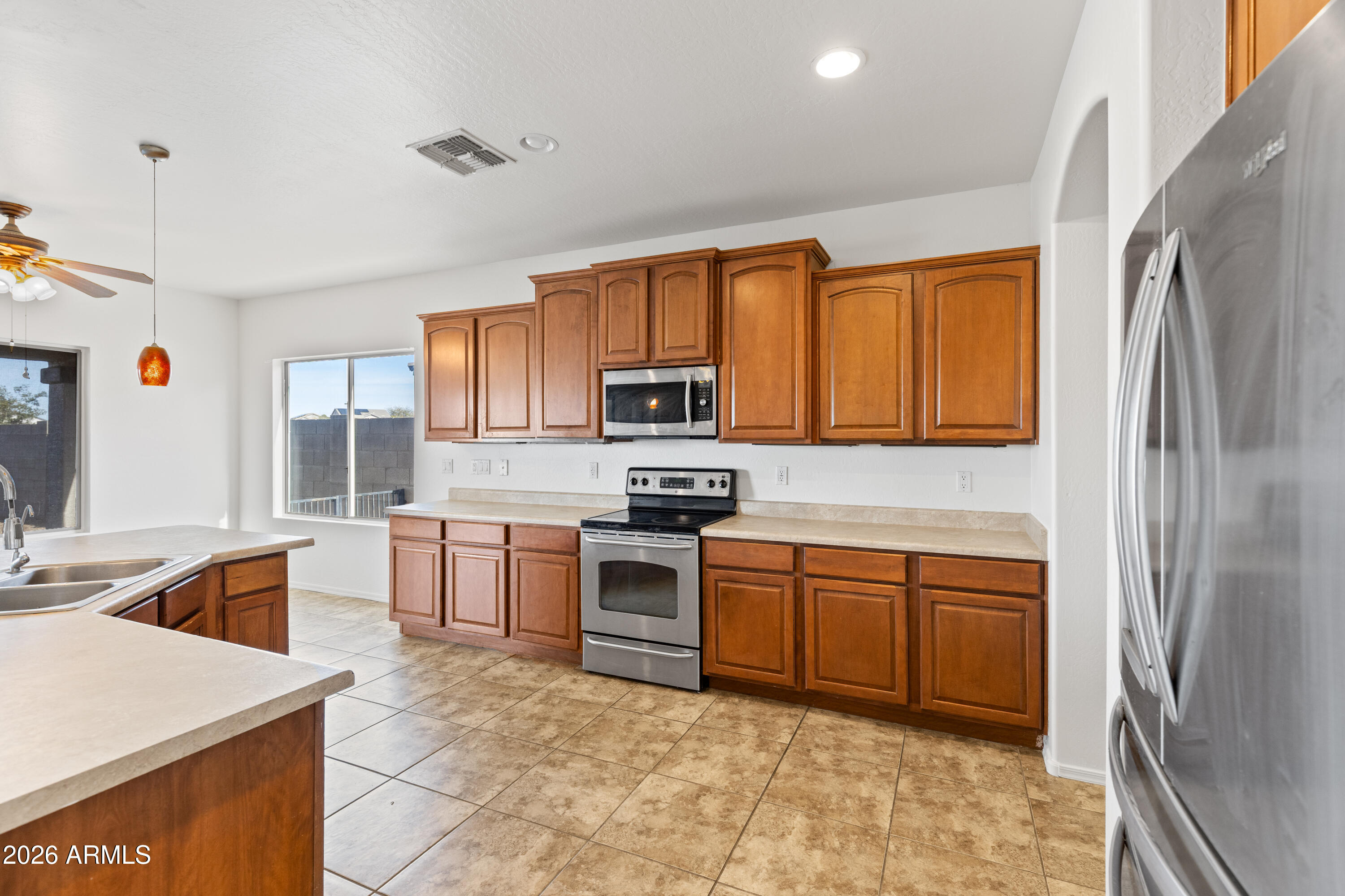 9840 Tangerine Road Florence, AZ 85132 - Photo 17 of 38 a kitchen with stainless steel appliances granite countertop a refrigerator a stove top oven a sink and dishwasher