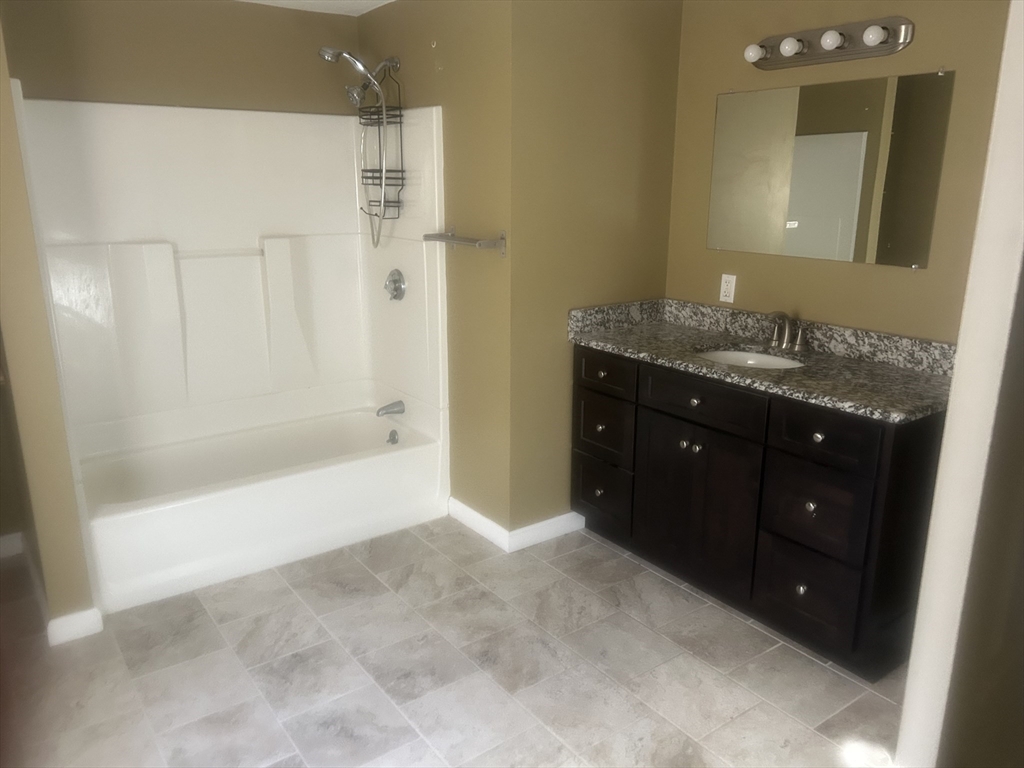 3 Julien Avenue Worcester, MA 01604 - Photo 4 of 8 a spacious bathroom with a bathtub sink and mirror