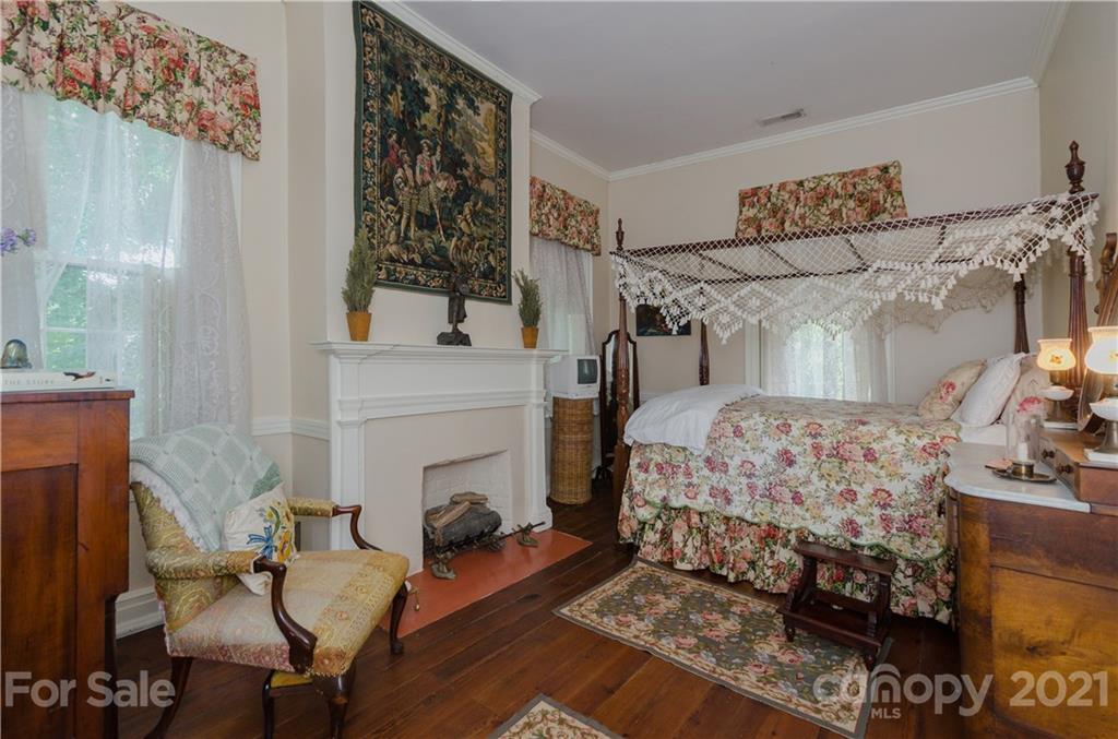 3379 Polk County Line Road Rutherfordton, NC 28139 - Photo 14 of 36 a bedroom with a bed a chair and a fireplace