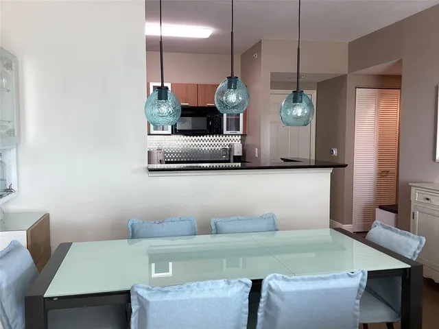 a kitchen with a table a microwave a stove and cabinets