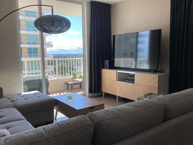 a living room with furniture and a floor to ceiling window