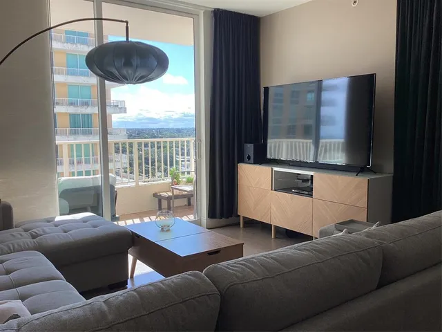 a living room with furniture and a floor to ceiling window
