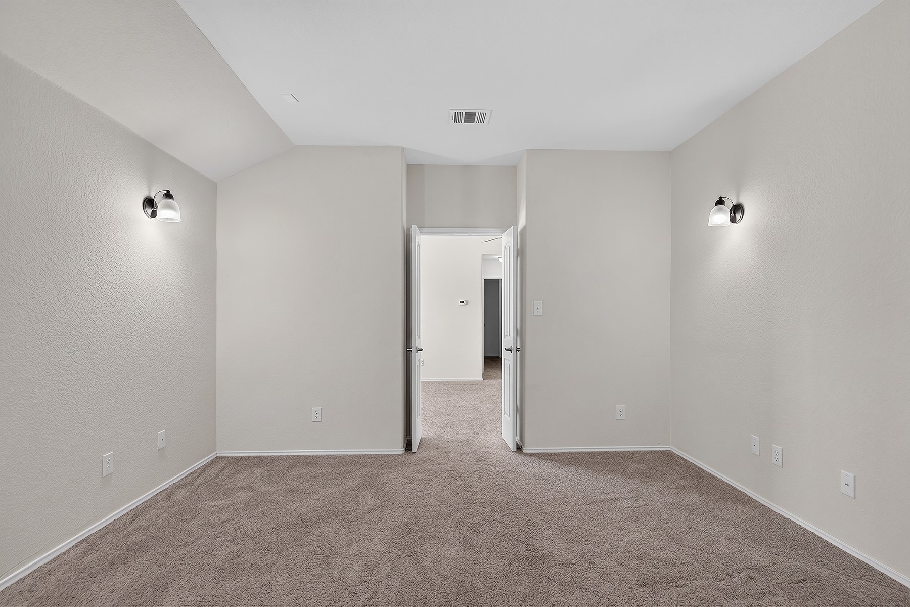 4601 Chestnut Meadows Bend Georgetown, TX 78626 - Photo 27 of 35 A spacious, naturally illuminated room featuring warm neutral carpeting and modern wall sconces.