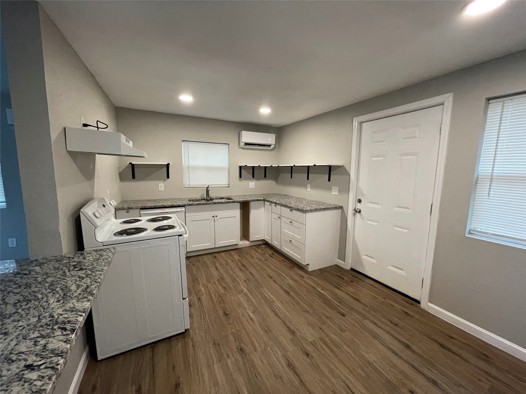 809 South Pierce Street Burnet, TX 78611 - Photo 2 of 7 Kitchen with white appliances, light stone counters, dark wood-type flooring, white cabinetry, and recessed lighting