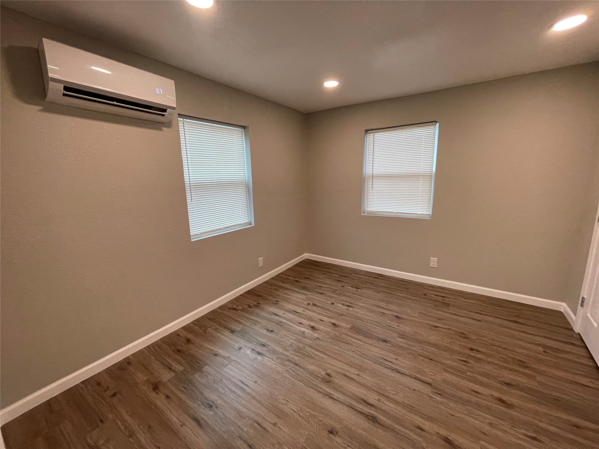 809 South Pierce Street Burnet, TX 78611 - Photo 4 of 7 Empty room featuring plenty of natural light, dark wood-type flooring, and recessed lighting