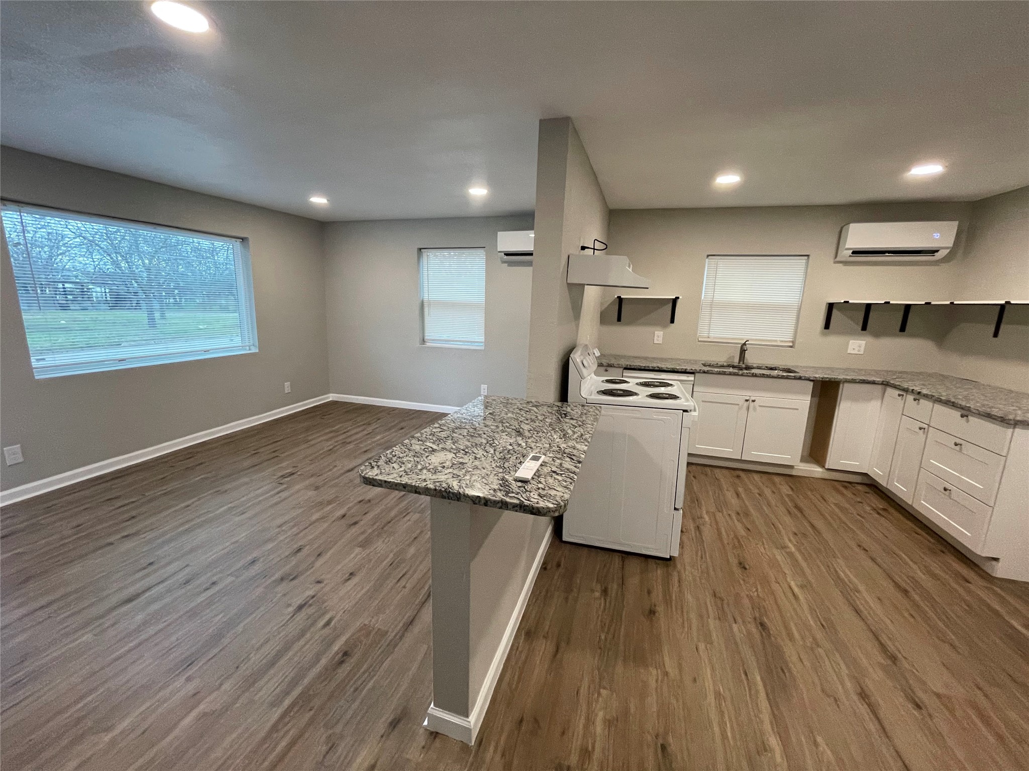 809 South Pierce Street Burnet, TX 78611 - Photo 5 of 7 Kitchen featuring a peninsula, white cabinets, electric range, light stone counters, and recessed lighting