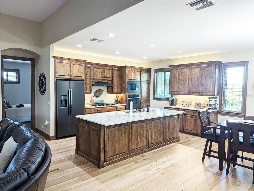 710 Albee Road West Nokomis, FL 34275 - Photo 12 of 30 a kitchen with stainless steel appliances granite countertop a table chairs and a refrigerator