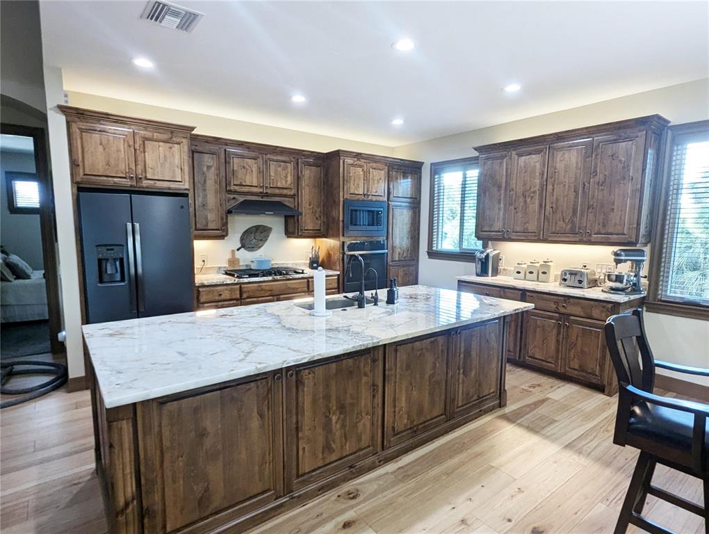 710 Albee Road West Nokomis, FL 34275 - Photo 13 of 30 a kitchen with granite countertop a stove a sink dishwasher a dining table and chairs with wooden floor