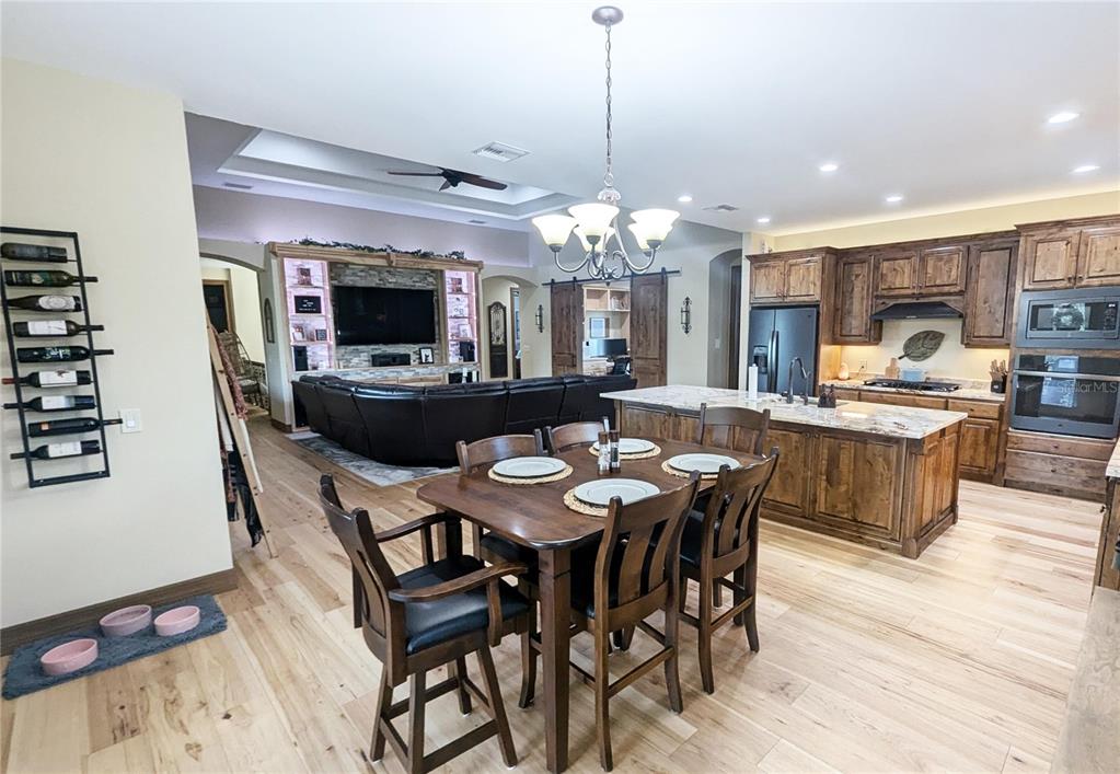 710 Albee Road West Nokomis, FL 34275 - Photo 15 of 30 a dining room with wooden floor a chandelier a wooden table and chairs