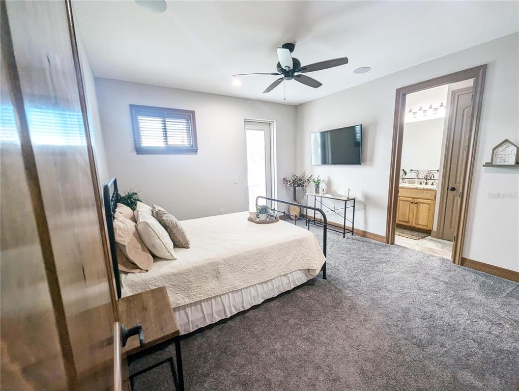 710 Albee Road West Nokomis, FL 34275 - Photo 23 of 30 a bedroom with a large bed and a chandelier