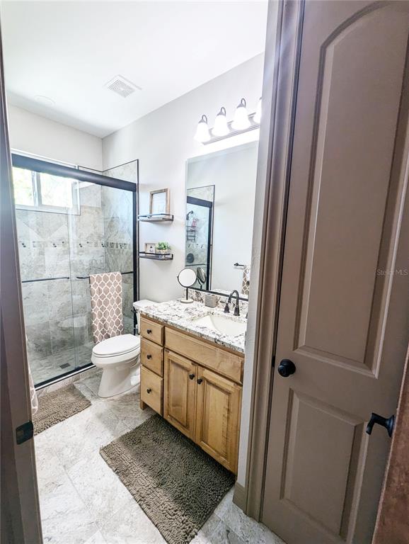 710 Albee Road West Nokomis, FL 34275 - Photo 24 of 30 a bathroom with a granite countertop sink toilet a mirror and shower