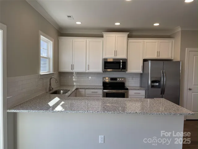 a kitchen with a sink a microwave a refrigerator and cabinets