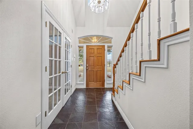 a view of staircase with lots of frames on wall and a window