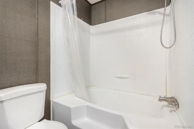 a bathroom with a toilet and a bath tub