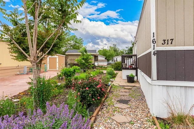 a house with lots of flowers in front of it