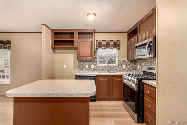 a kitchen with stainless steel appliances granite countertop a sink stove and cabinets