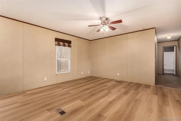 an empty room with windows and fan