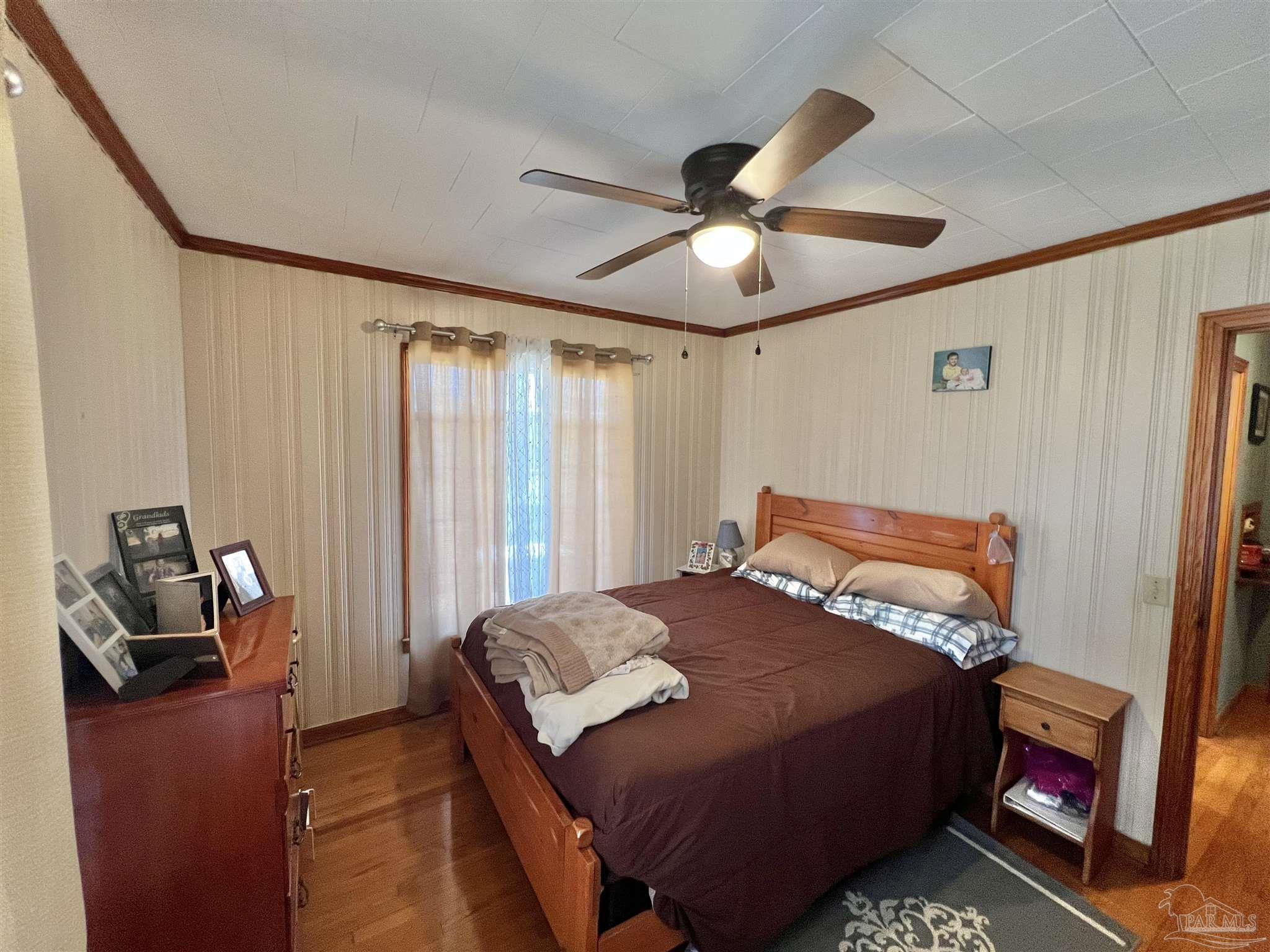 707 East Horner Street Atmore, AL 36502 - Photo 18 of 28 a bedroom with a bed and a chandelier