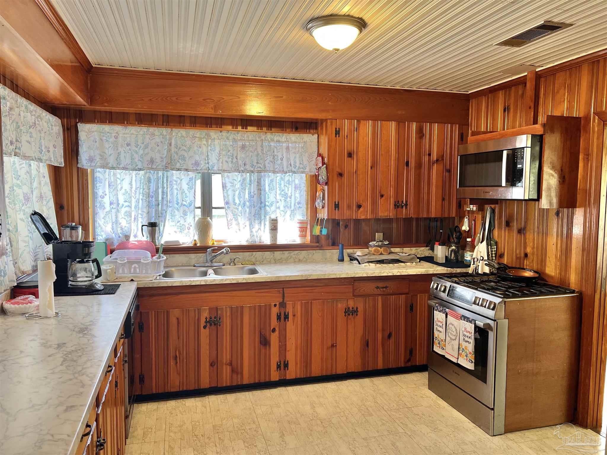 707 East Horner Street Atmore, AL 36502 - Photo 10 of 28 a kitchen with stainless steel appliances granite countertop a stove a sink dishwasher and a microwave oven with large cabinets