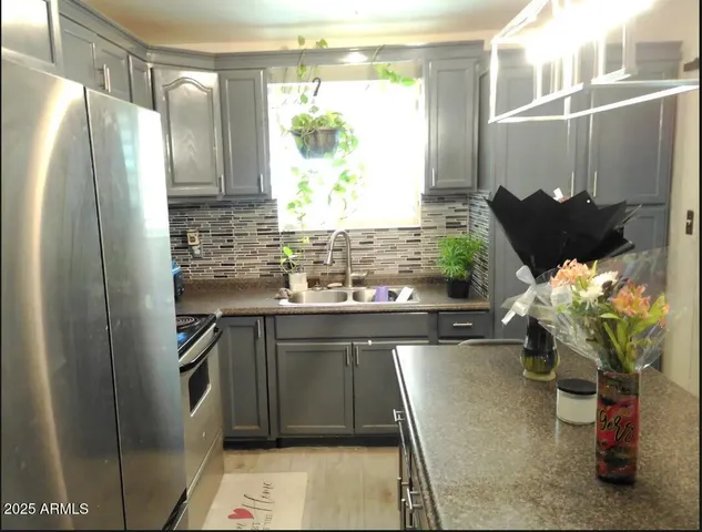 a kitchen with stainless steel appliances granite countertop a sink and a refrigerator