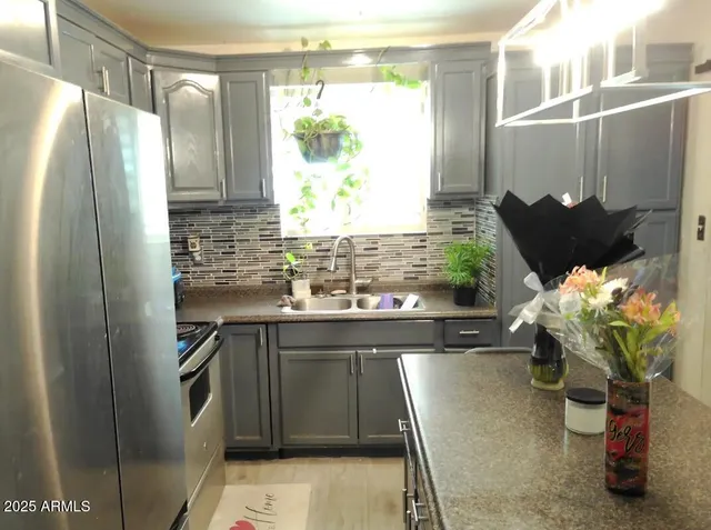 a kitchen with stainless steel appliances a refrigerator a sink and a cabinets