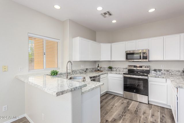 a kitchen with stainless steel appliances granite countertop a sink stove and cabinets