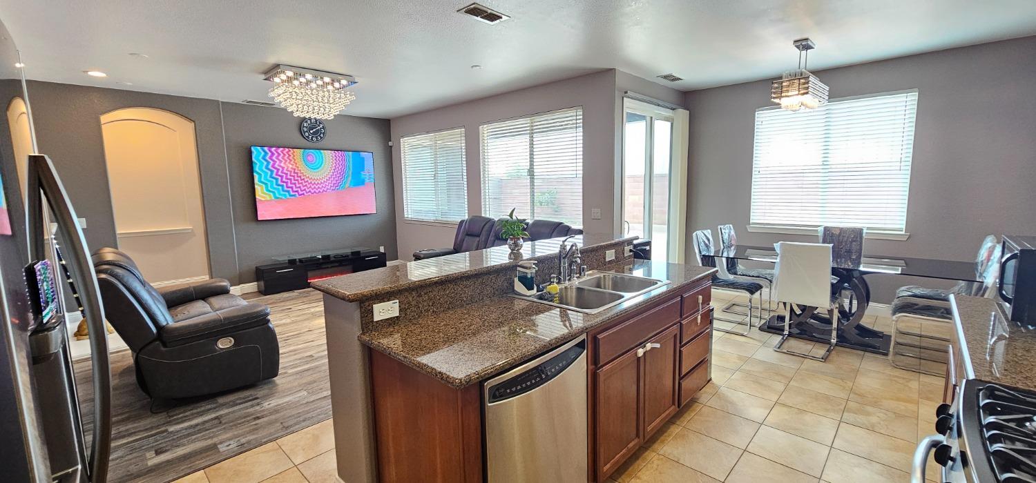 11724 Brook Valley Way Rancho Cordova, CA 95742 - Photo 24 of 32 a view of a kitchen with kitchen island granite countertop a sink and a refrigerator