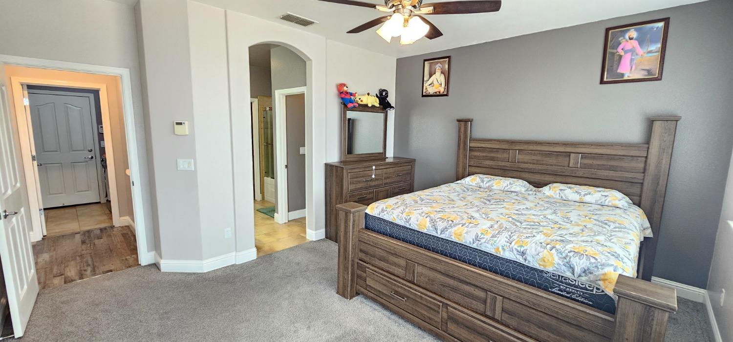 11724 Brook Valley Way Rancho Cordova, CA 95742 - Photo 28 of 32 a bedroom with a bed and a chandelier