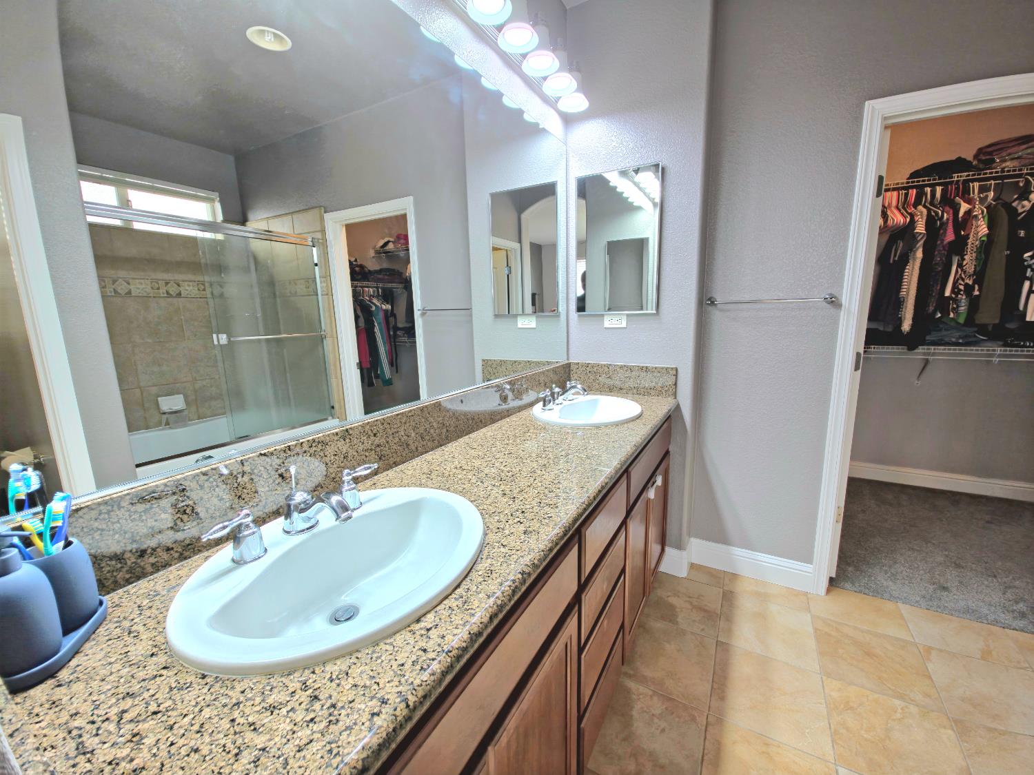 11724 Brook Valley Way Rancho Cordova, CA 95742 - Photo 9 of 32 a bathroom with a granite countertop sink a mirror and shower