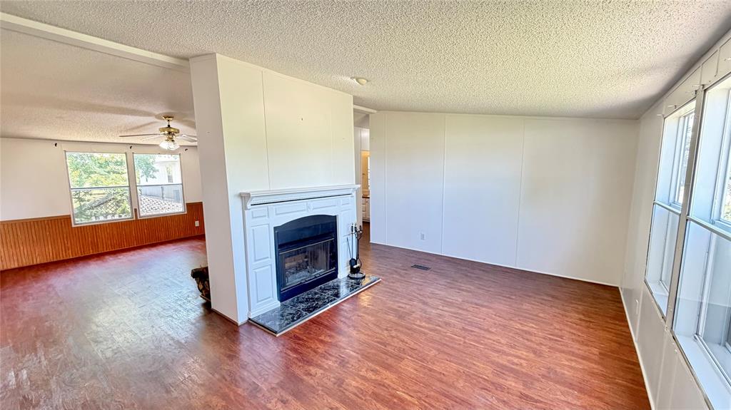 3789 Jacobs Lane Kaufman, TX 75142 - Photo 13 of 33 a view of a livingroom with wooden floor a fireplace and window