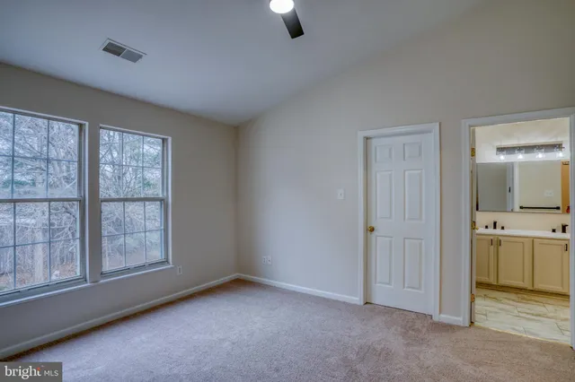 an empty room with windows and bathroom view