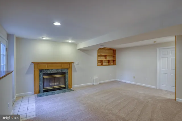 a view of empty room with a fireplace and window