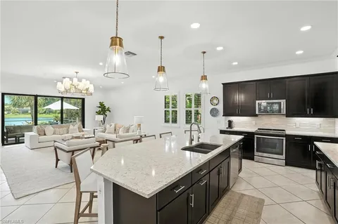 a kitchen with kitchen island stainless steel appliances a sink and a center island