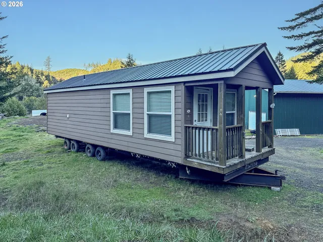 a view of a house with a wooden deck and a yard