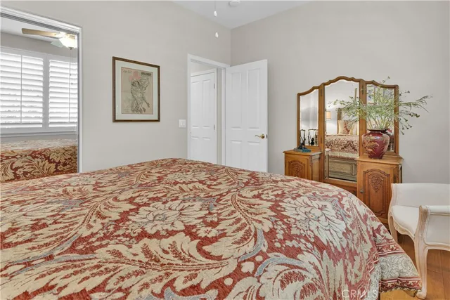 a bedroom with a large bed and a chandelier fan