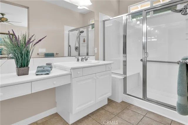 a bathroom with a granite countertop sink a mirror and shower