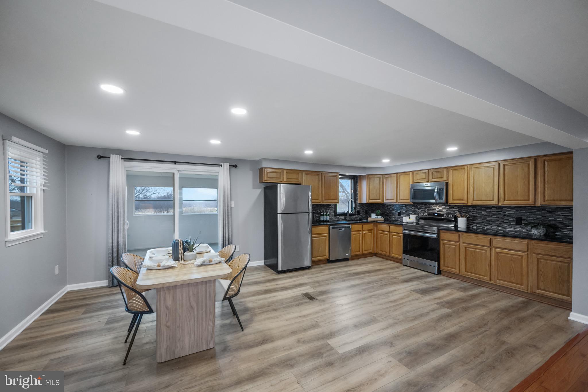 15915 Trenton Road Upperco, MD 21155 - Photo 11 of 41 a kitchen with stainless steel appliances kitchen island granite countertop a stove a sink a refrigerator dining table and chairs