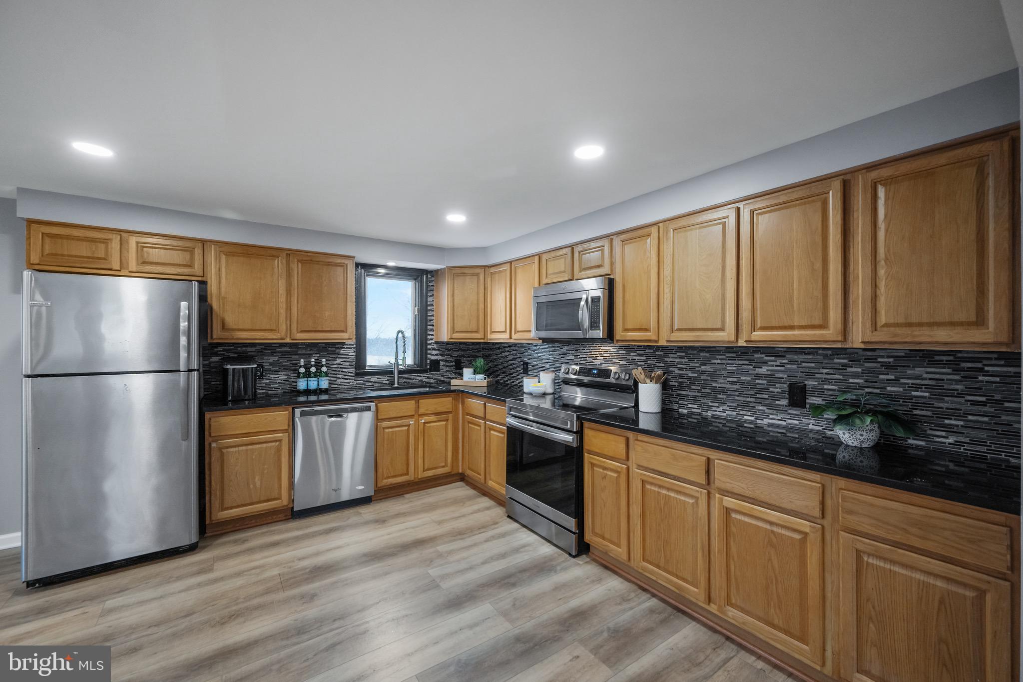 15915 Trenton Road Upperco, MD 21155 - Photo 13 of 41 a kitchen with stainless steel appliances granite countertop a refrigerator a stove top oven a sink and dishwasher with wooden floor