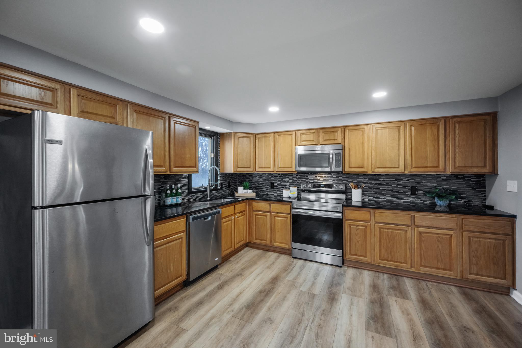15915 Trenton Road Upperco, MD 21155 - Photo 14 of 41 a kitchen with stainless steel appliances granite countertop a refrigerator a sink dishwasher a stove and white countertops with wooden floor