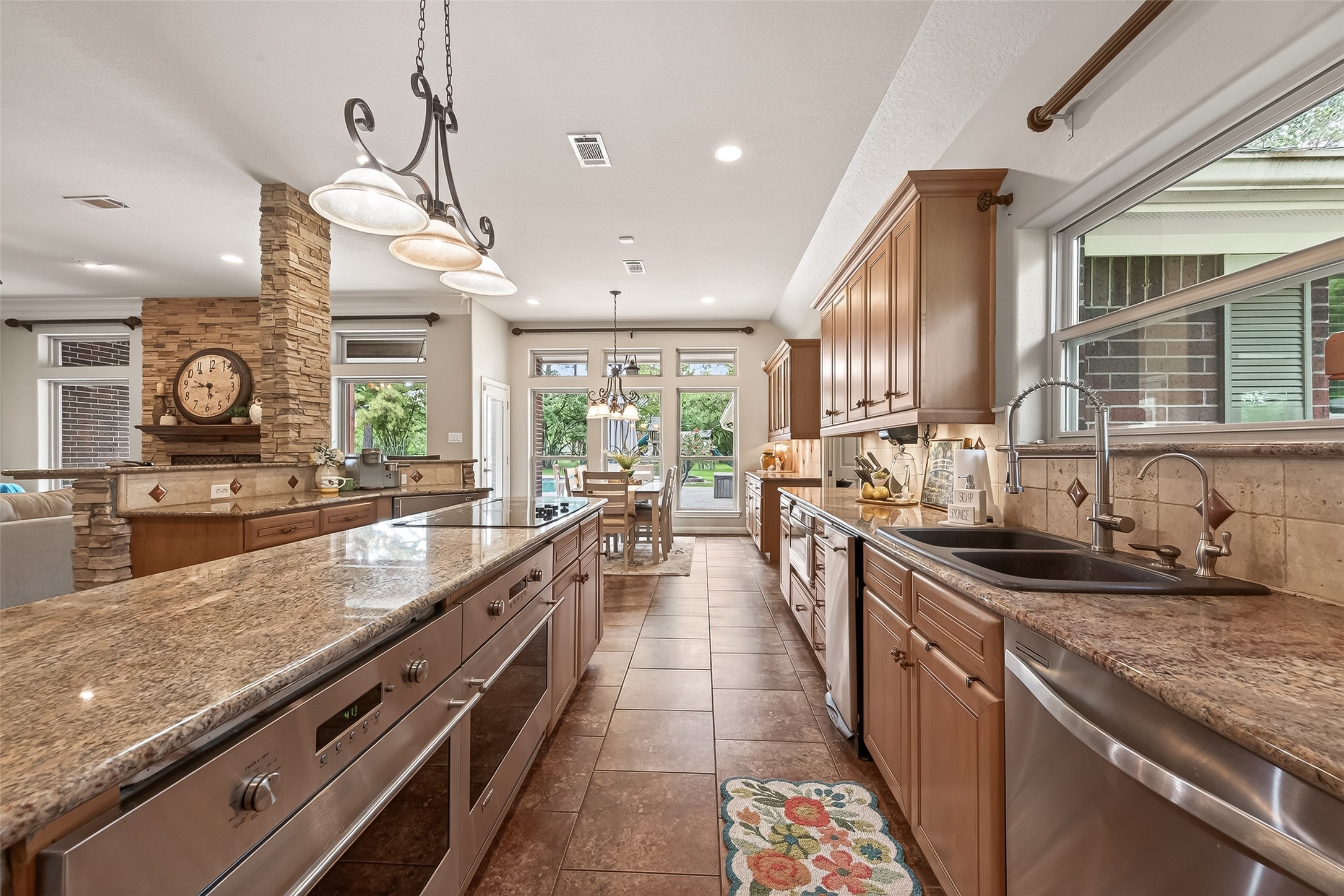 17603 Bending Cypress Road Cypress, TX 77429 - Photo 11 of 43 The spacious kitchen features elegant granite countertops, a large central island with built-in appliances, and abundant natural light. It seamlessly connects to a cozy dining area, perfect for entertaining.